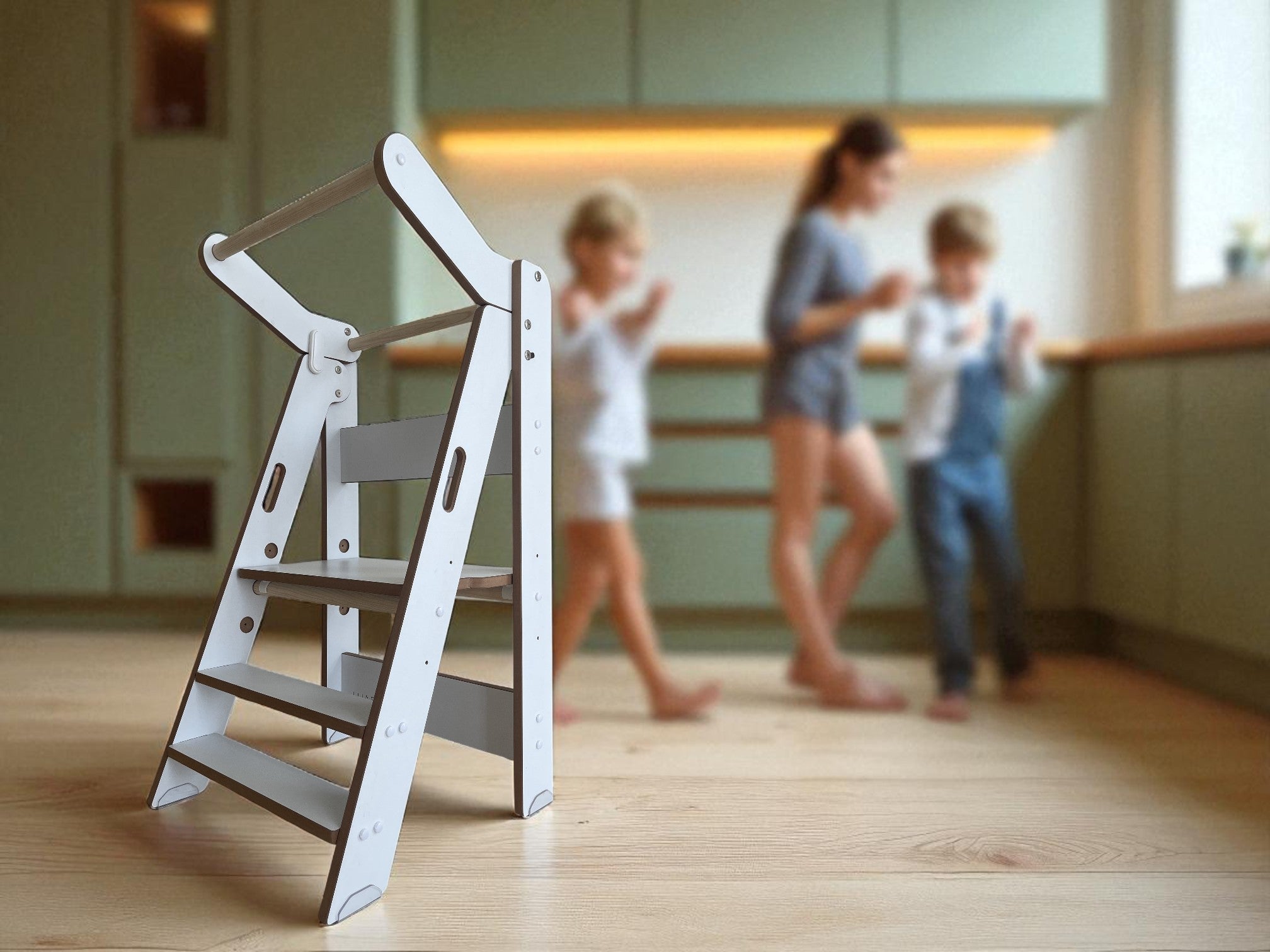 Torre Plegable ZALU en cocina con familia de fondo desenfocado, convivencia y aprendizaje en casa.