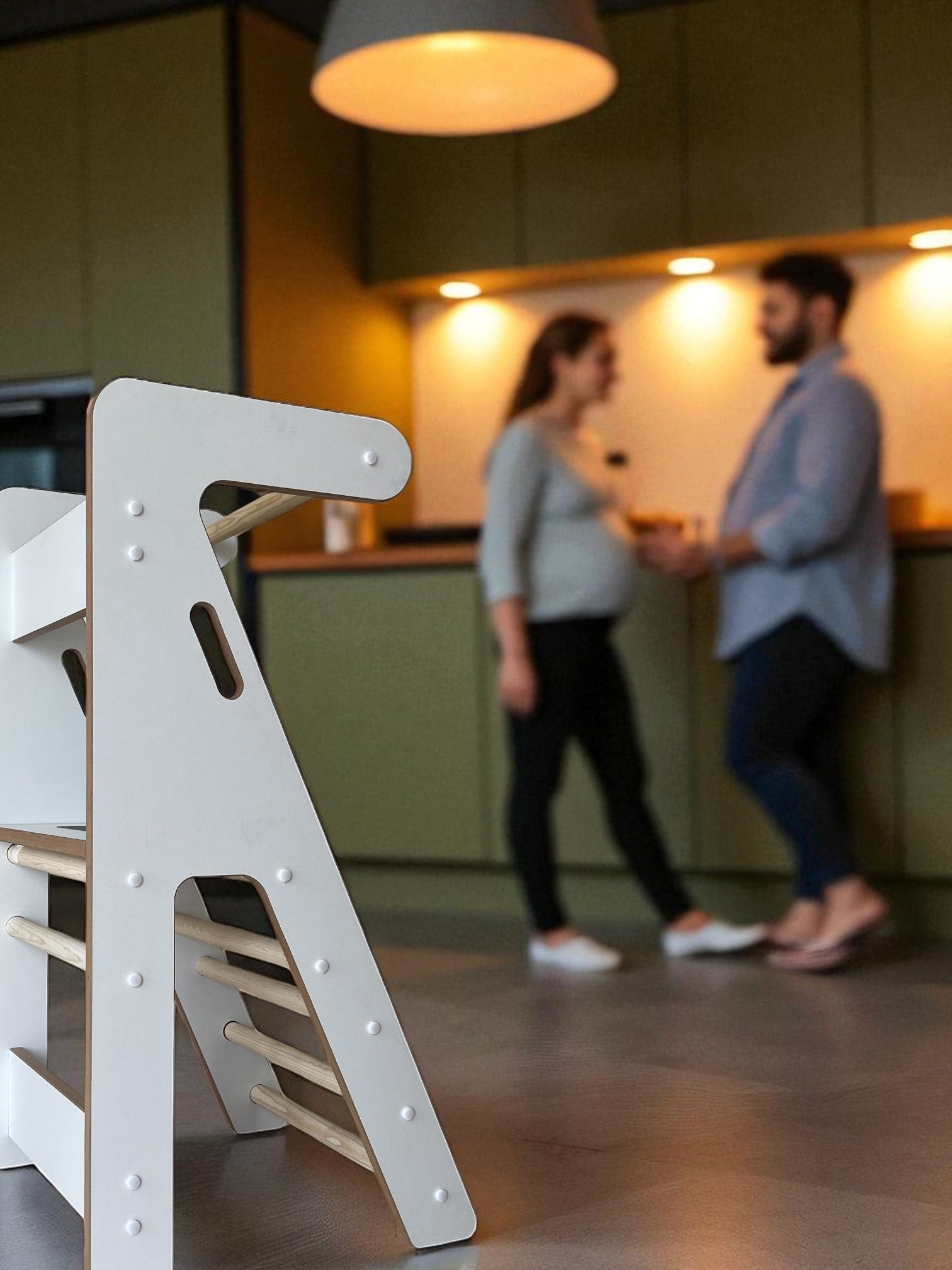 Torre compacta Zalu en ambiente de cocina, con una pareja embarazada desenfocados al fondo.