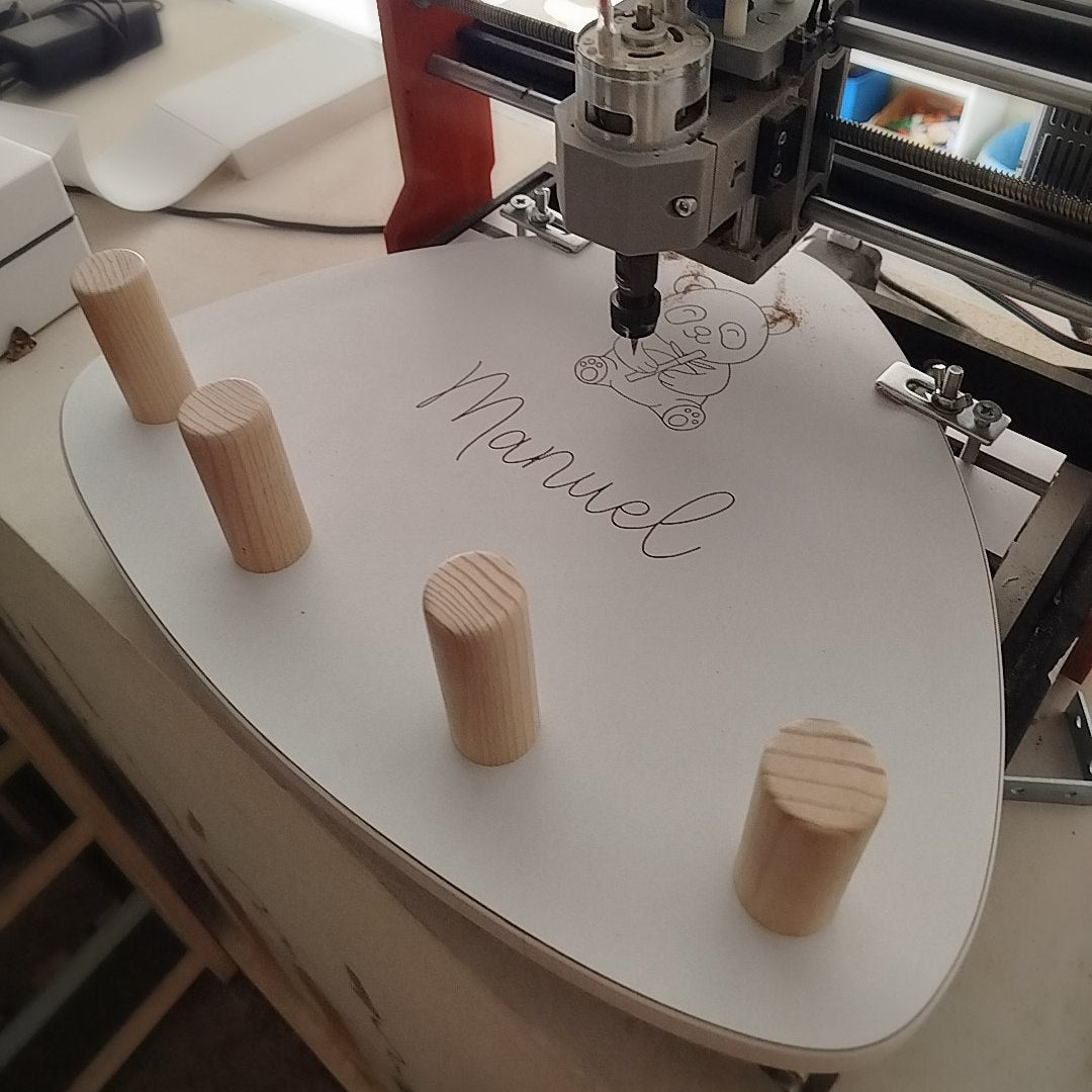 MAquina cnc grabando sobre perchero zalu un dibujo personalizado