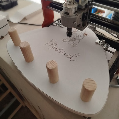 MAquina cnc grabando sobre perchero zalu un dibujo personalizado