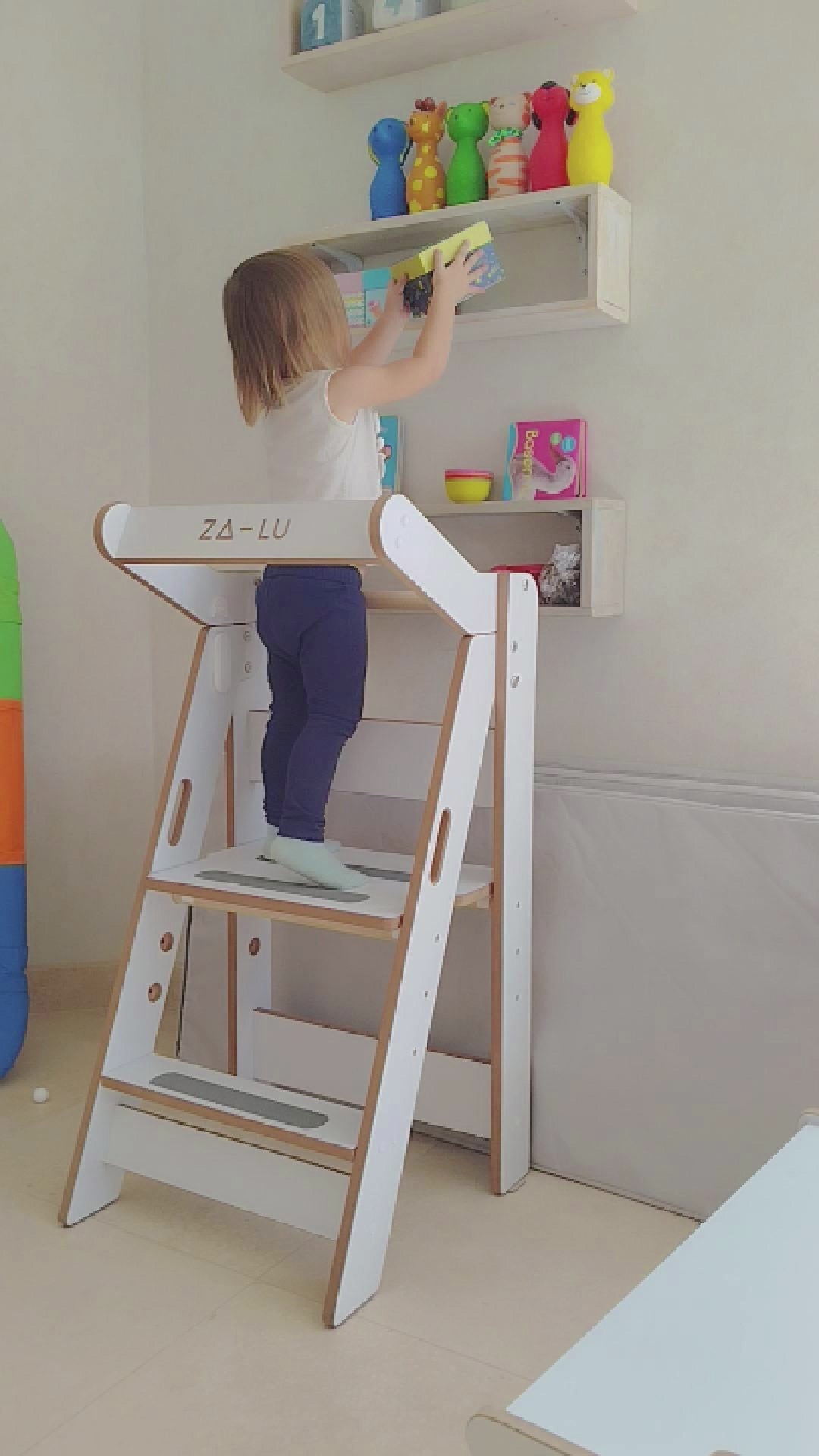 niña de 2.5 años acomoda una caja con la torre de aprendizaje montessori zalu